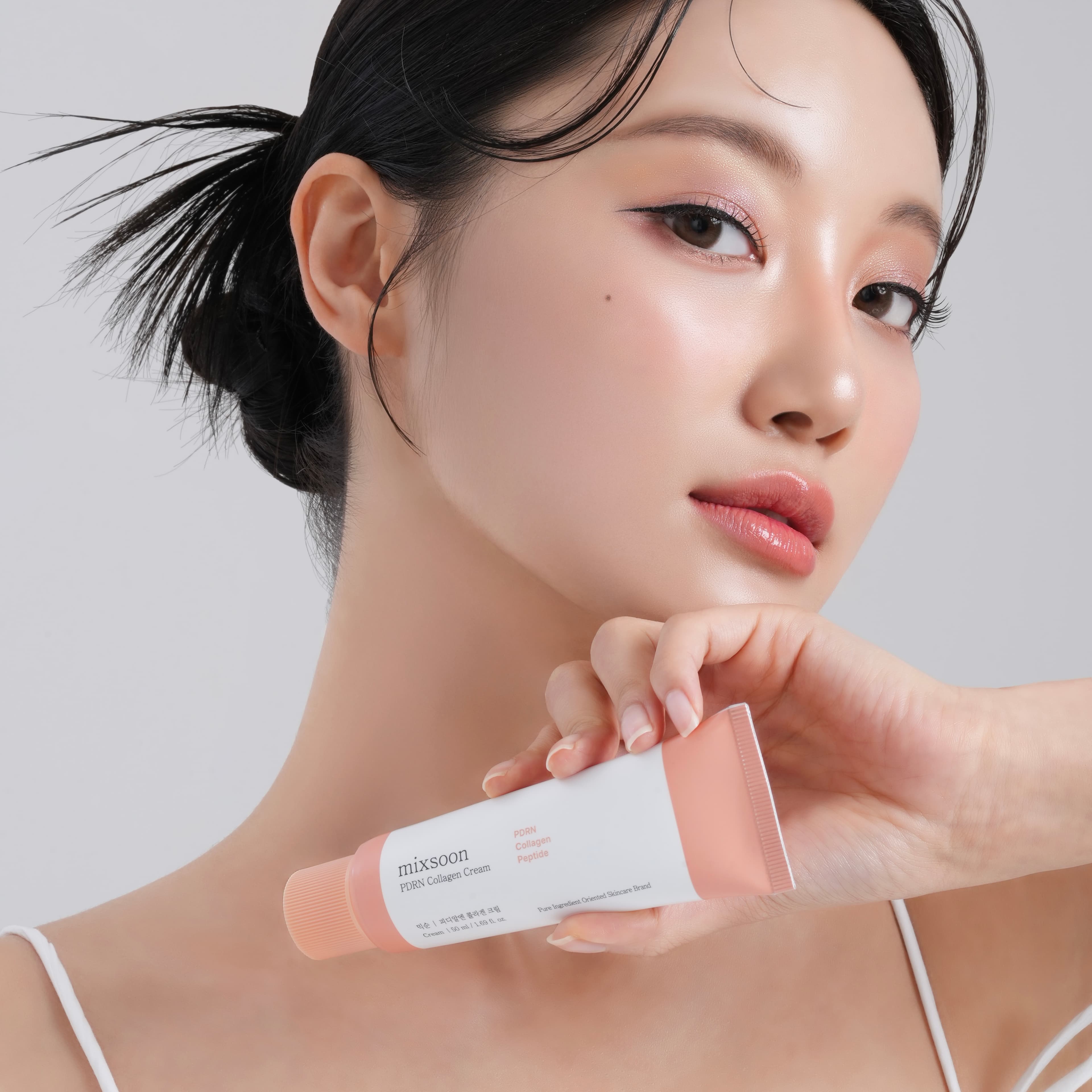 Model ținând crema mixsoon PDRN Collagen Cream, cu un ten luminos și o rutină simplă