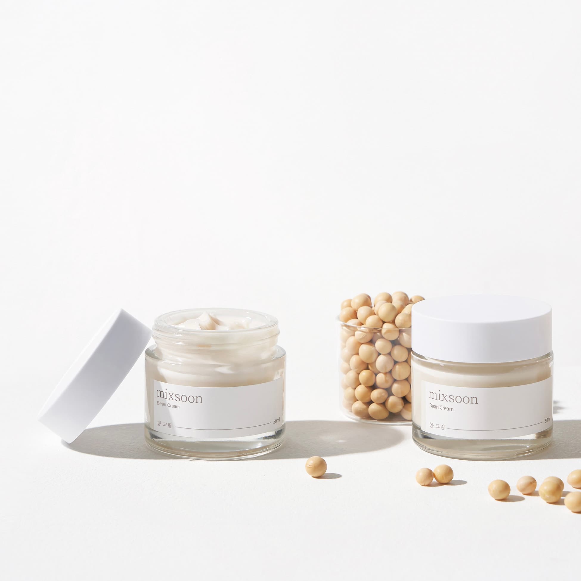 Două borcane mixsoon Bean Cream alături de boabe de soia